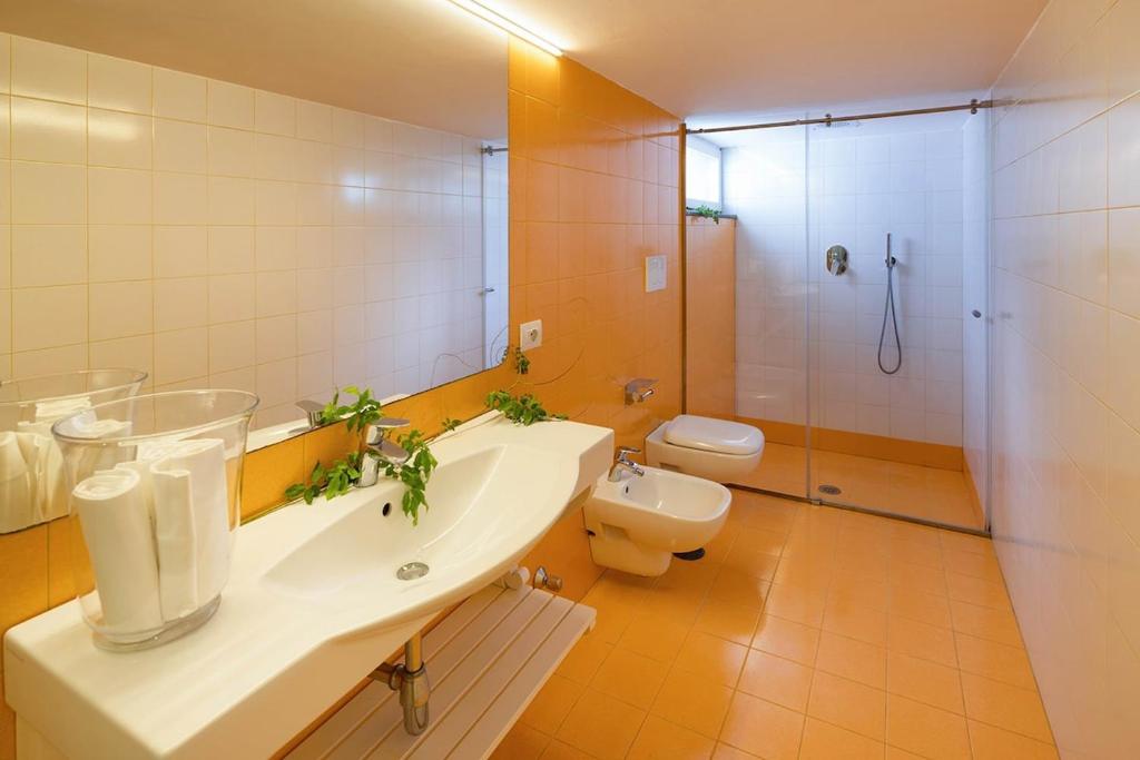 une salle de bain avec un lavabo, des toilettes et une douche dans l'établissement Villa Marinella close to the sea with private pool, à Nerano
