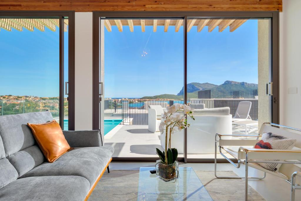 - un salon avec un canapé et une vue sur la piscine dans l'établissement Villa MIrto - Golfo Aranci, Baia Caddinas Sardinia, Costa Smeralda, à Golfo Aranci
