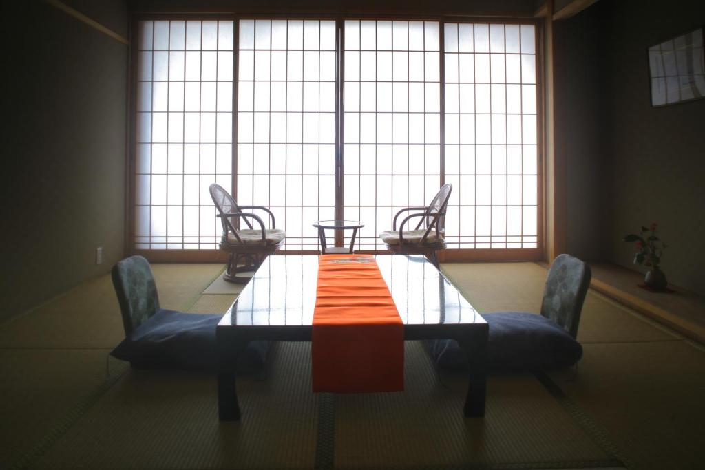 une table et des chaises devant une grande fenêtre dans l'établissement Ryokan Yukeikohan Suitenkaku, à Matsue 7 autres photos