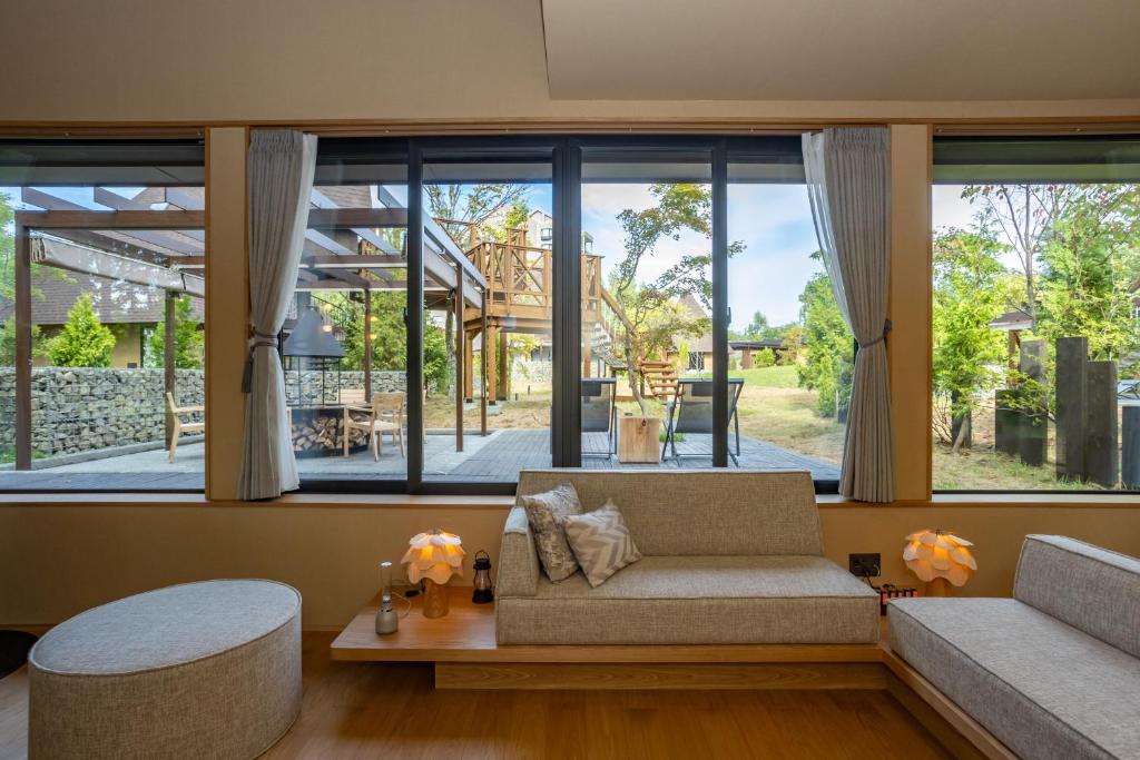 un salon avec un canapé et une grande fenêtre dans l'établissement Hokuten no Oka Abashiriko Tsuruga Resort, à Abashiri