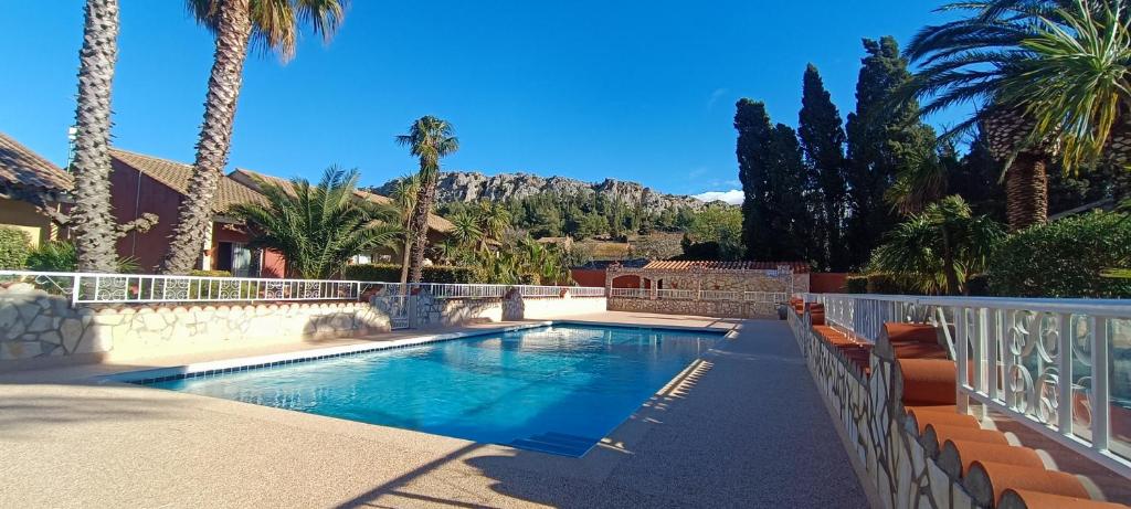 une piscine avec des palmiers et une maison dans l'établissement Gite la Capelle Roquefort des Corbières Sigean Narbonne Aude, à Roquefort-des-Corbières 37 autres photos