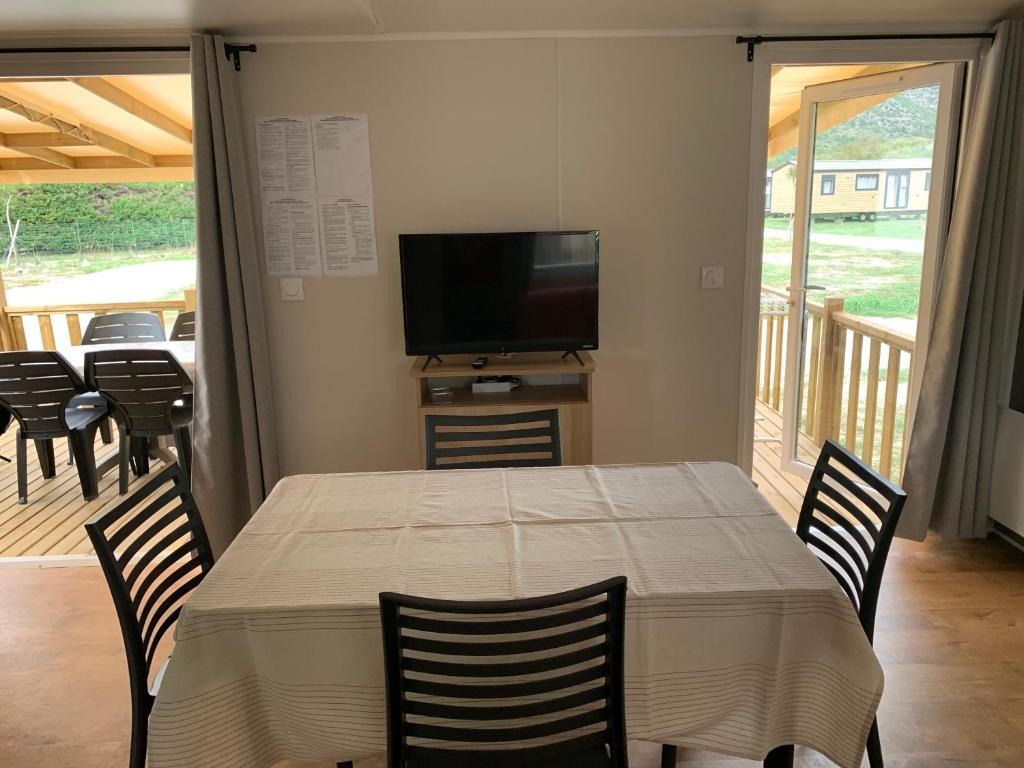 une salle à manger avec une table, des chaises et une télévision dans l'établissement Calme & Sérénité, à Flaviac