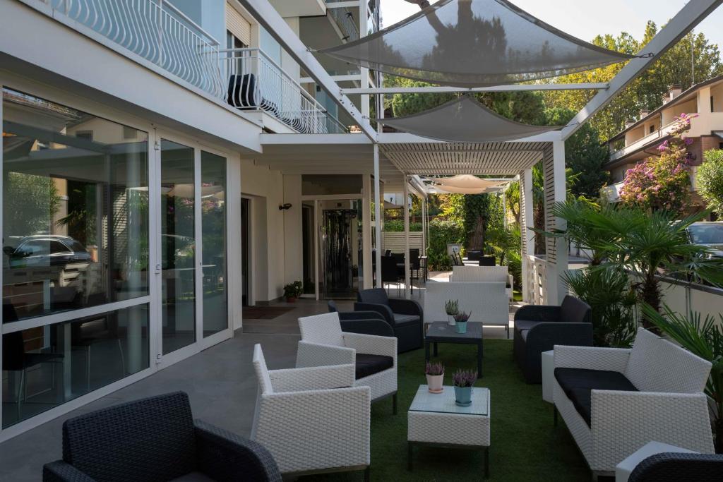 un patio avec des canapés et des chaises dans un bâtiment dans l'établissement Hotel Smart Cervia B&B, à Cervia