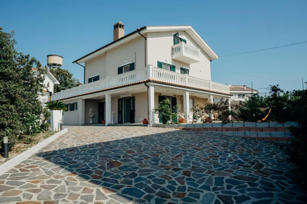 une grande maison blanche avec une allée en pierre dans l'établissement Casa Vacanze Di Luzio, à Pescara