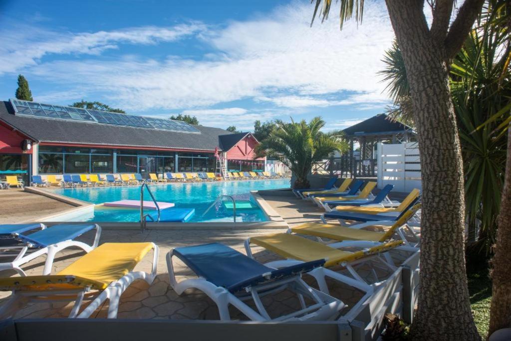 une rangée de chaises longues à côté d'une piscine dans l'établissement Domaine de karlann 4Etoiles Mobil-home, à Pont-Aven