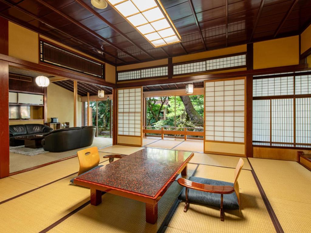 un salon avec une table et des chaises en bois dans l'établissement Hoshi, à Komatsu