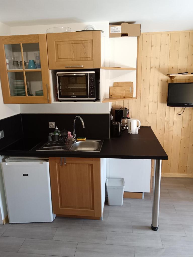 une petite cuisine avec un évier et un micro-ondes dans l'établissement Appartement plein sud, Val Thorens Centre, à Val Thorens