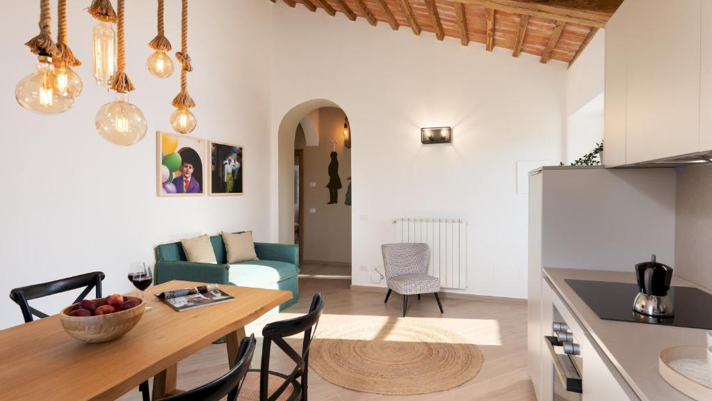 une cuisine et un salon avec une table et des chaises dans l'établissement CASOLARE SAN MARTINO 16&1, Emma Villas, à Pomarance