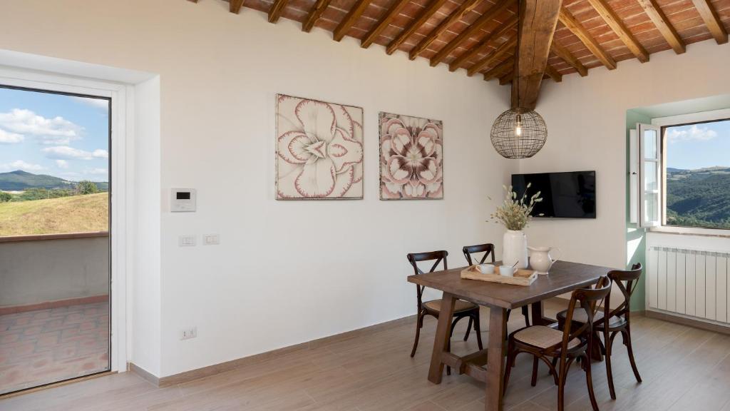 une salle à manger avec une table et des chaises et une télévision dans l'établissement CASOLARE SAN MARTINO 16&1, Emma Villas, à Pomarance