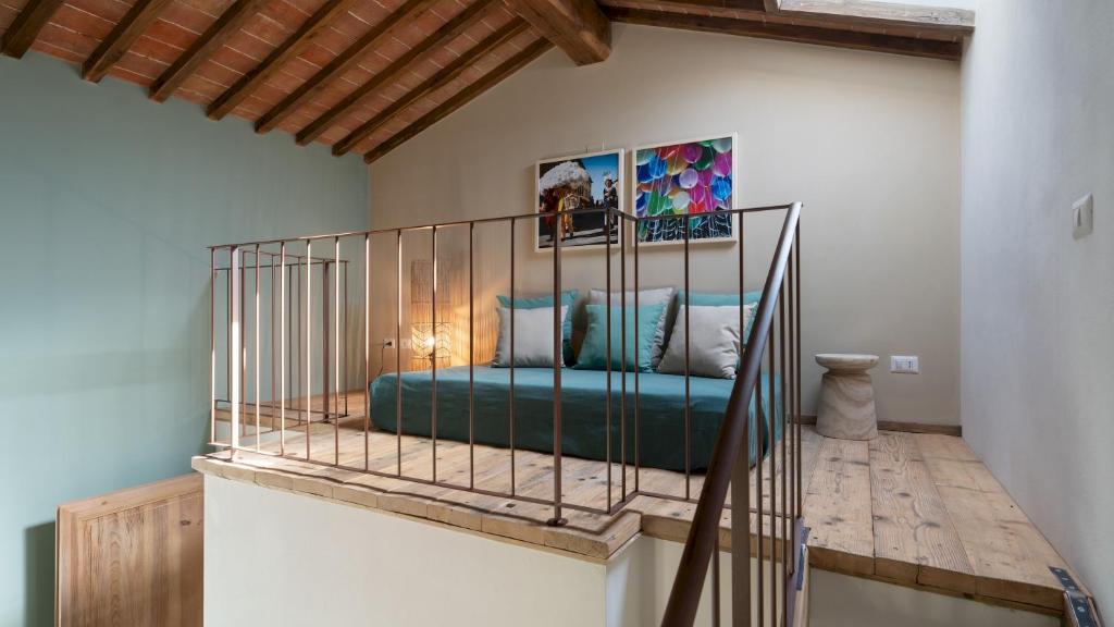 - un lit en métal dans une chambre avec un escalier dans l'établissement CASOLARE SAN MARTINO 16&1, Emma Villas, à Pomarance