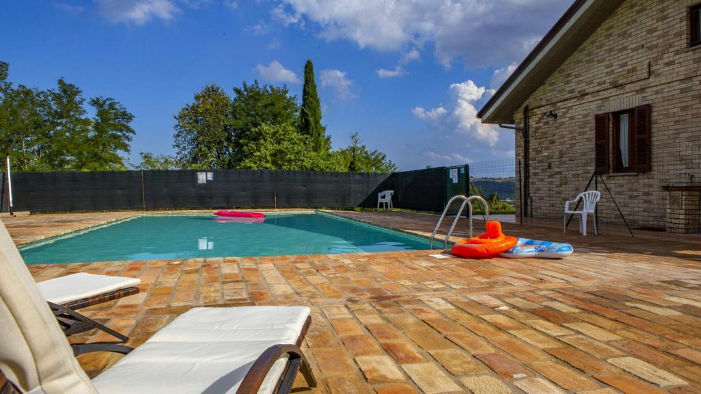 une piscine dans une cour à côté d'une maison dans l'établissement Villa Domus - Homelike Villas, à Montegiorgio