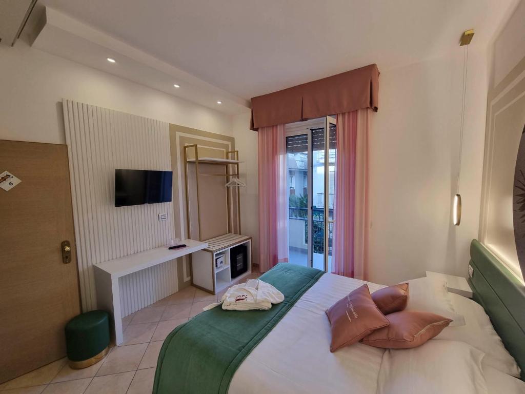 - une chambre avec un lit doté d'oreillers et une télévision dans l'établissement Hotel Angelini, à Rimini