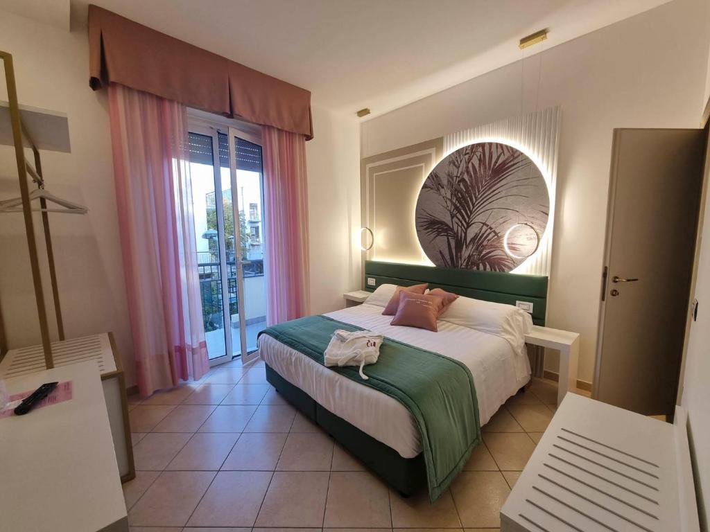 une chambre avec un lit et une grande fenêtre dans l'établissement Hotel Angelini, à Rimini