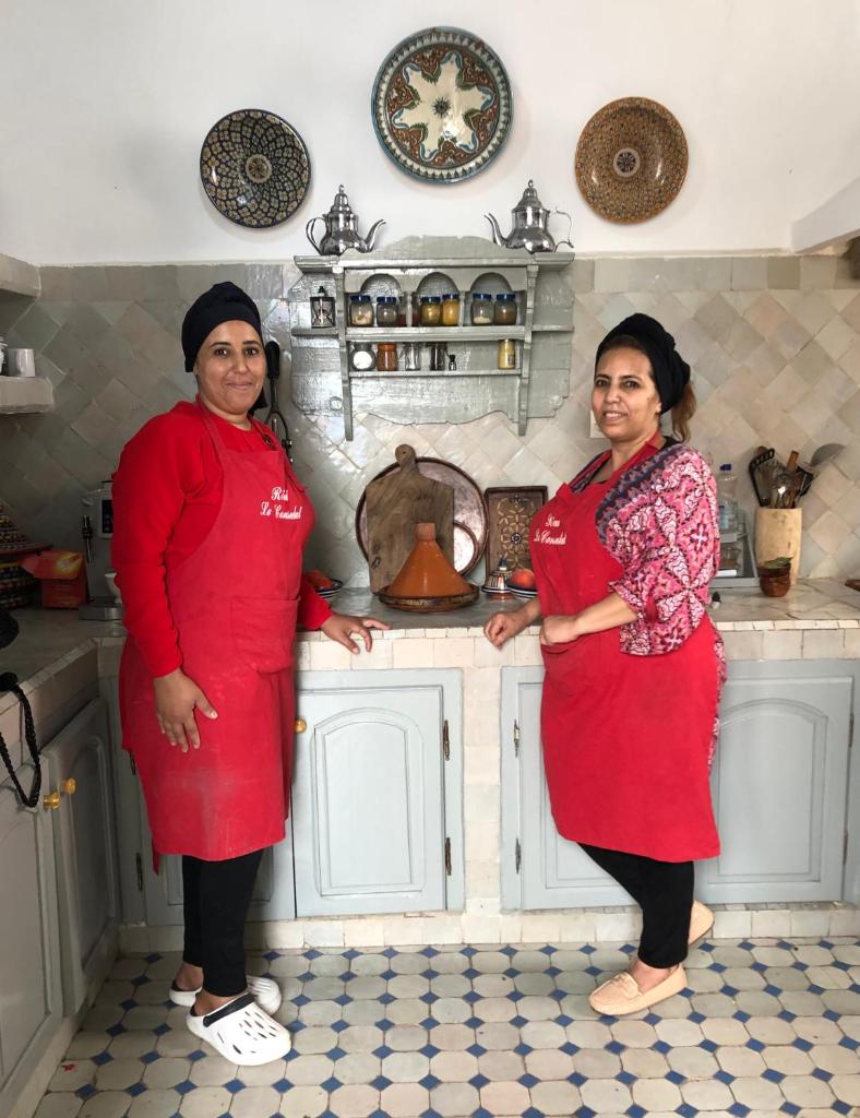 Deux femmes sont debout dans une cuisine dans l'établissement Riad le Consulat - chambre d'hôtes, à Essaouira