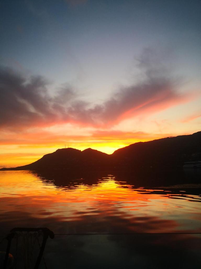 un coucher de soleil sur un lac avec des montagnes en arrière-plan dans l'établissement seuls à bord dans le golfe hebergement atypique, à Porto-Vecchio