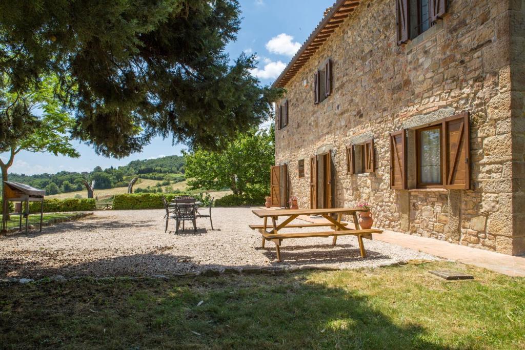 - une table de pique-nique devant un bâtiment en pierre dans l'établissement Villa Orizzonte - Homelike Villas, à Todi