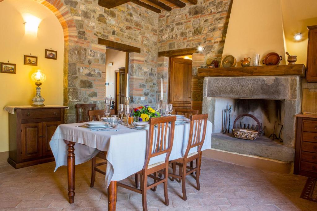 une salle à manger avec une table et une cheminée dans l'établissement Villa Orizzonte - Homelike Villas, à Todi