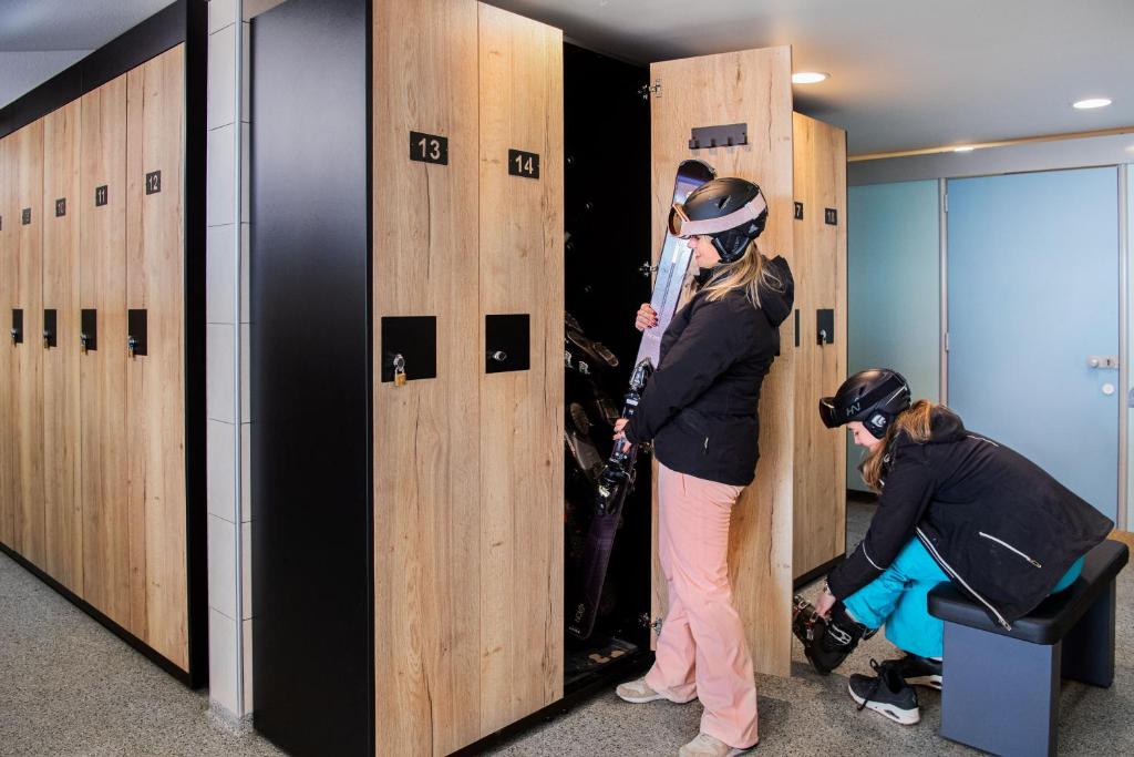 - deux personnes debout dans un vestiaire dans l'établissement Camping RCN Belledonne, au Bourg-dʼOisans