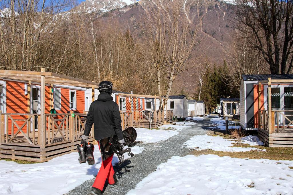une personne marchant dans une rue couverte de neige dans l'établissement Camping RCN Belledonne, au Bourg-dʼOisans
