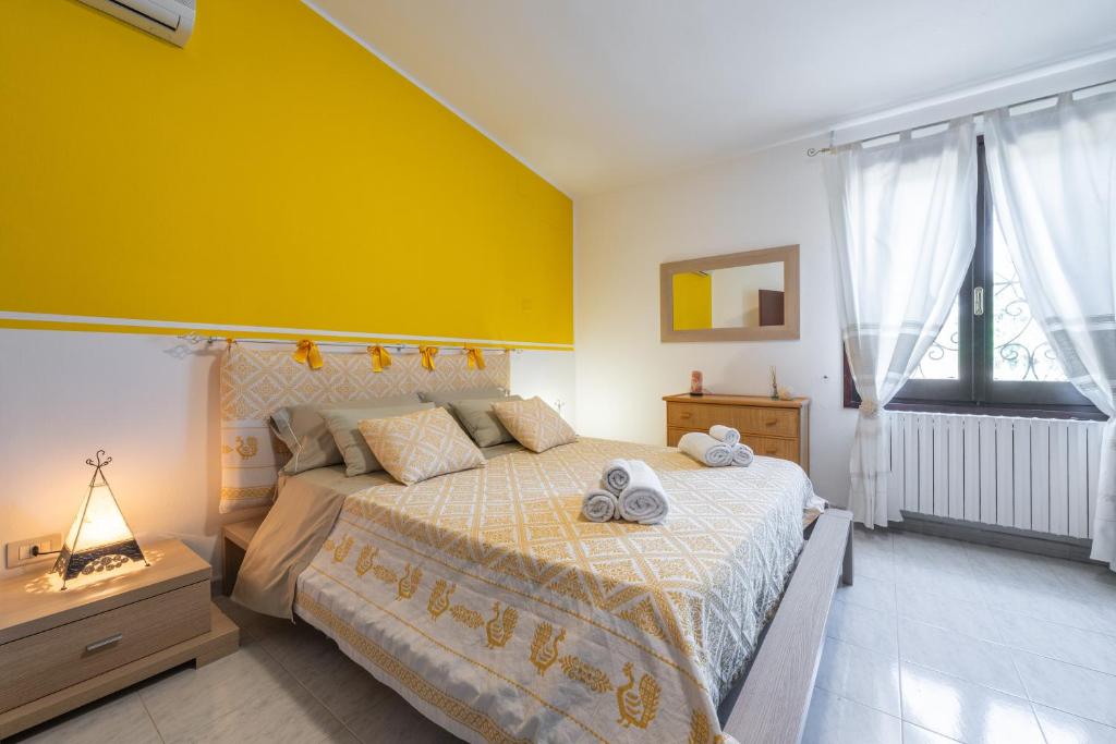 une chambre avec un lit avec un mur jaune dans l'établissement Villa Mavi, à Quartucciu