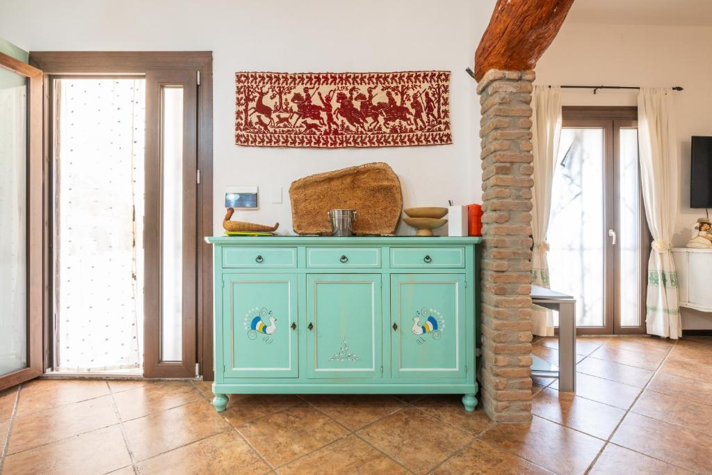 un cabinet turquoise dans une chambre avec fenêtres dans l'établissement Villa Mavi, à Quartucciu