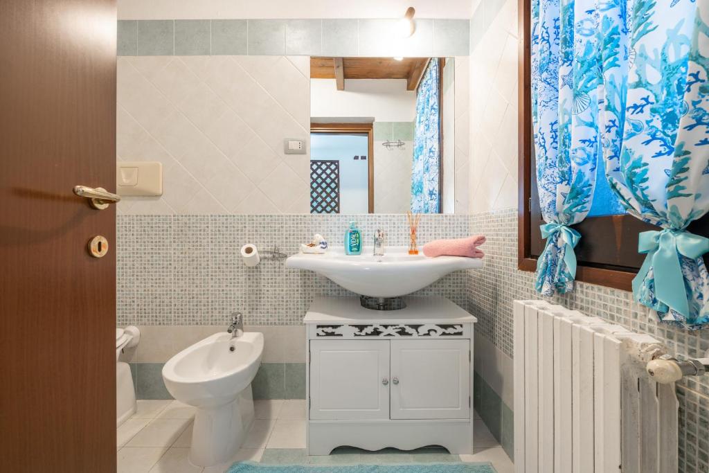 une salle de bain avec un lavabo, des toilettes et un miroir dans l'établissement Villa Mavi, à Quartucciu