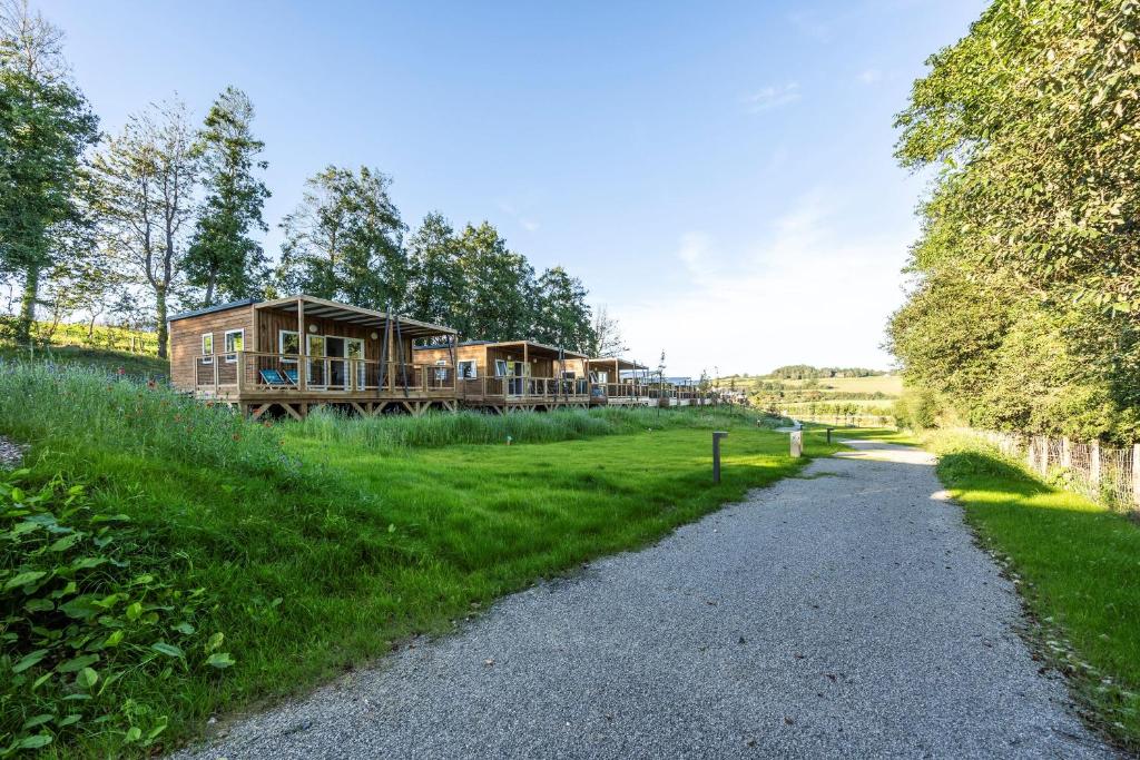 une maison au milieu d'un champ avec une route en gravier dans l'établissement Camping Domaine Saâne et Mer, à Quiberville