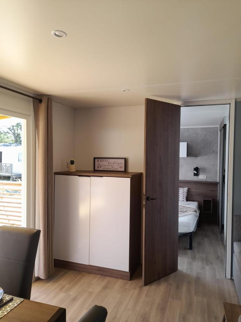 une pièce avec une porte menant à une chambre dans l'établissement camping la carabasse, à Vias