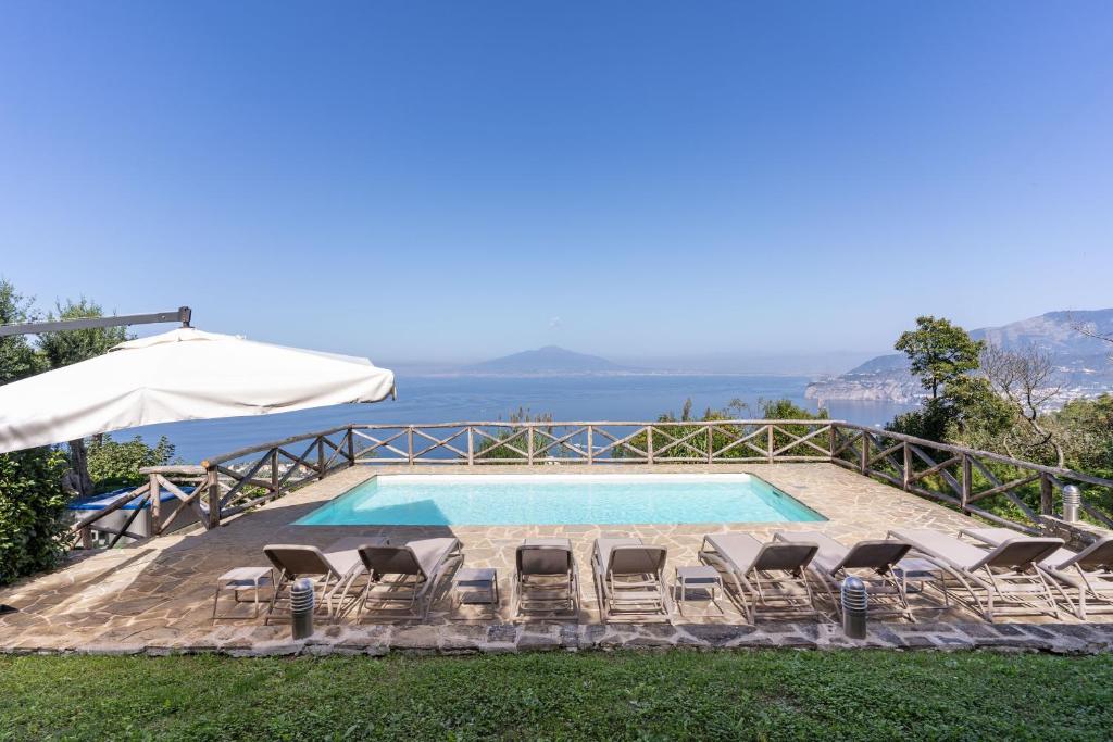 une piscine avec des chaises et un parasol dans l'établissement Villa Giulia Boutique Views Pool and Guest Services by Feeling Italy, à Sorrente