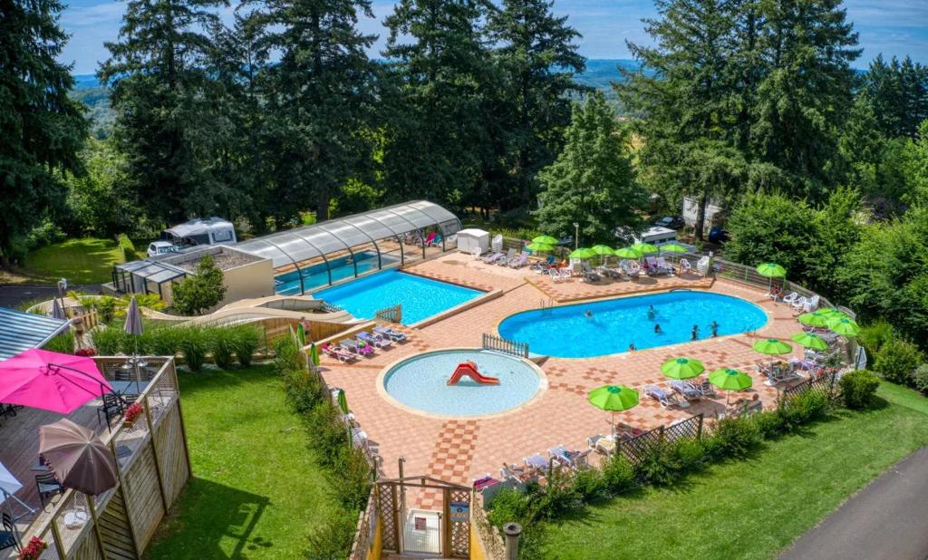 une vue aérienne d'une piscine avec des parasols dans l'établissement Glamping Payrac, à Payrac
