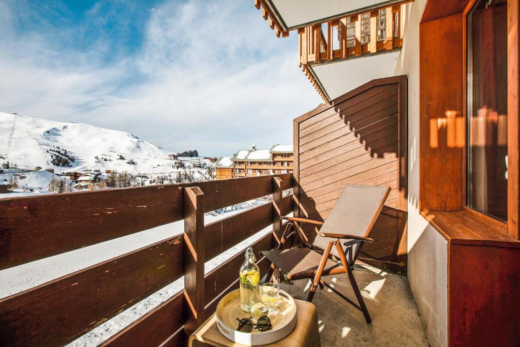 d'un balcon avec une table, des chaises et une montagne. dans l'établissement Résidence Pierre & Vacances Le Mont Soleil, à La Plagne
