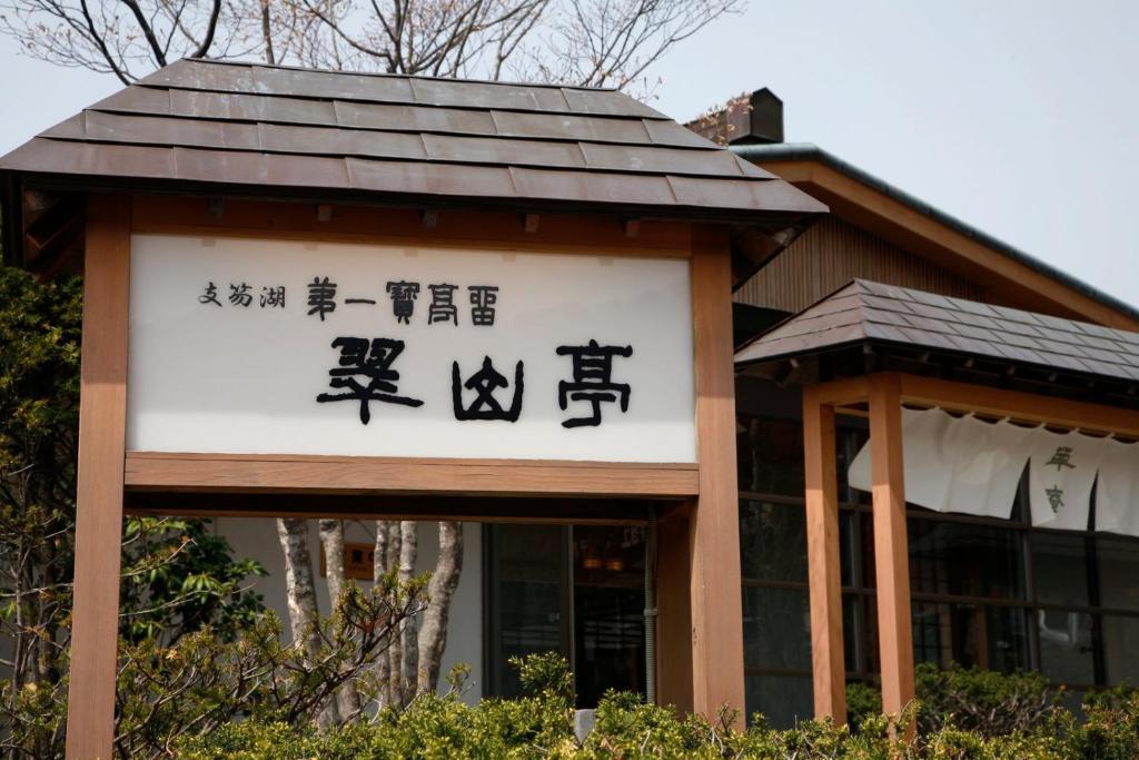 un panneau pour un bâtiment avec écriture sur celui-ci dans l'établissement Shikotsuko Daiichi Hotel Suizantei, à Chitose