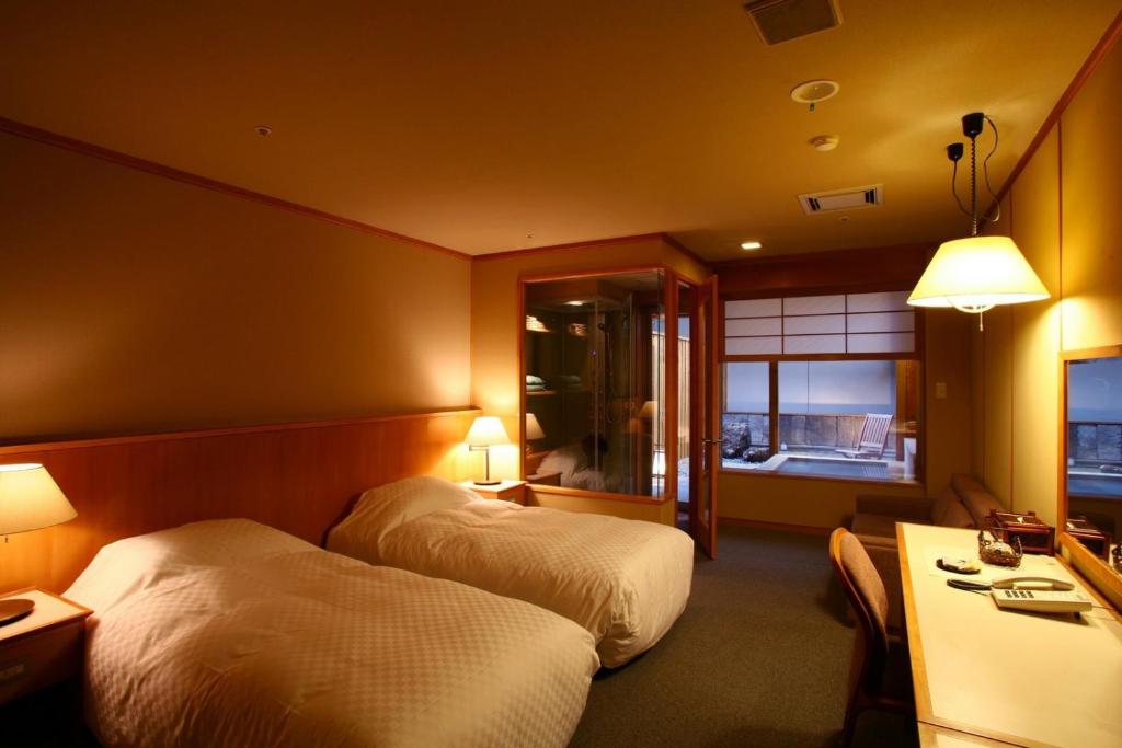 une chambre d'hôtel avec deux lits et une télévision dans l'établissement Shikotsuko Daiichi Hotel Suizantei, à Chitose
