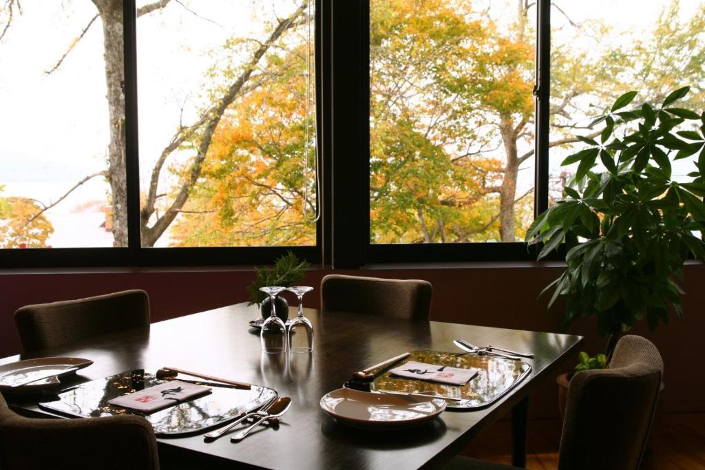 - une table à manger avec des chaises et 2 fenêtres dans l'établissement Ame no Hi to Yuyake-Adult Only, à Chitose