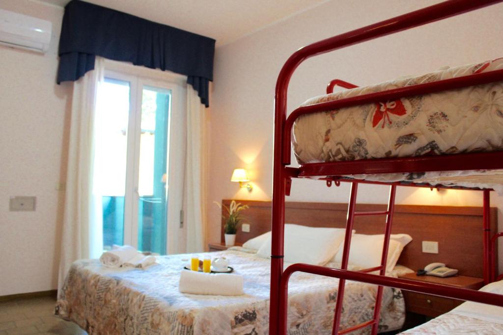 une chambre avec deux lits superposés et une fenêtre dans l'établissement Hotel Jole, à Cesenatico