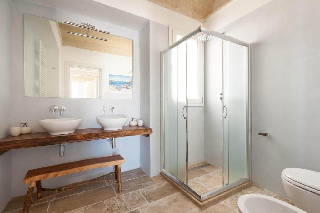 une salle de bain avec deux lavabos et une douche en verre dans l'établissement La Serrazza by Perle di Puglia, à Marina di Pescoluse 40 autres photos