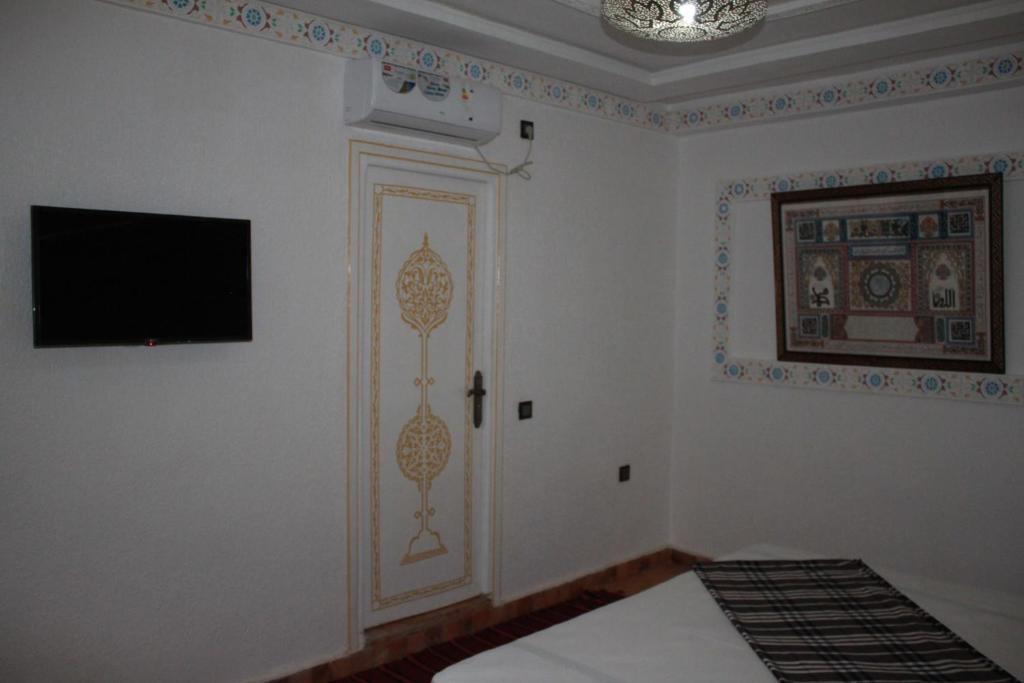 Cette chambre dispose d'une porte et d'une télévision murale. dans l'établissement Riad golf stinia, à Meknès