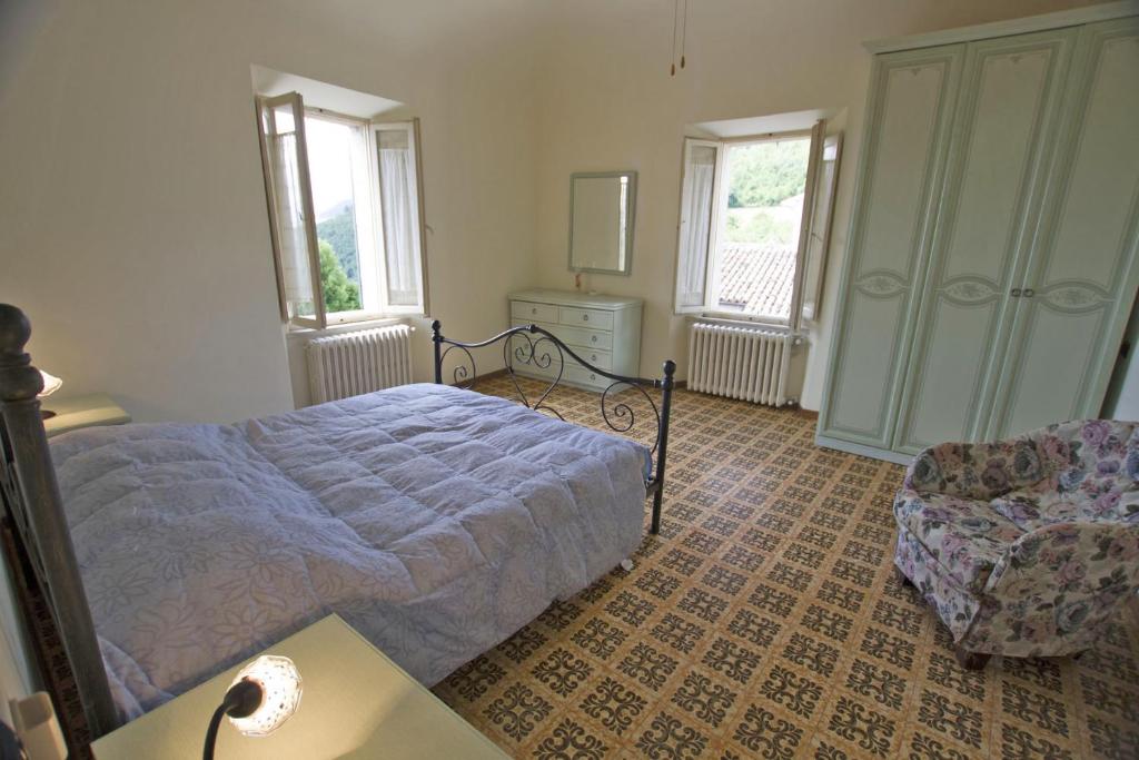 une chambre avec un lit et une chaise dans l'établissement Villa le Colline - Homelike Villas, à Cingoli
