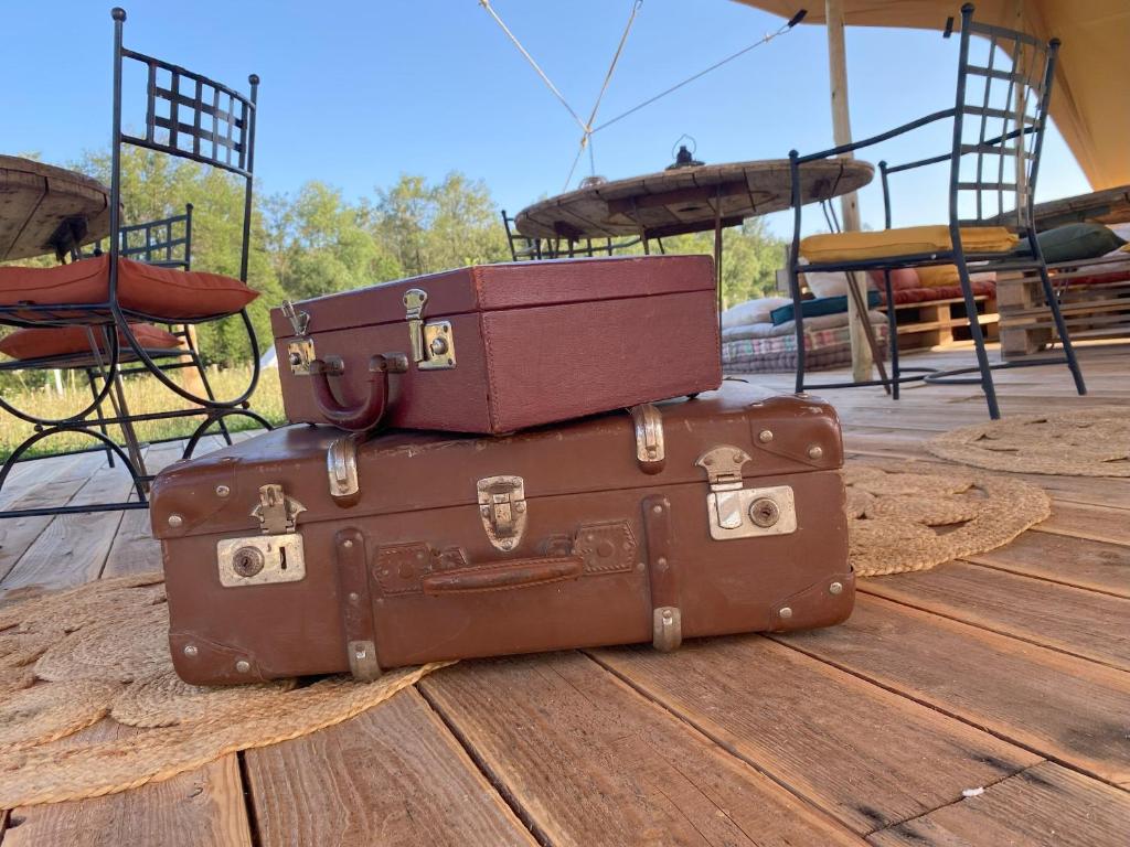 trois valises empilées les unes sur les autres sur un parquet dans l'établissement La Bêle & Toile, à Thiel-sur-Acolin