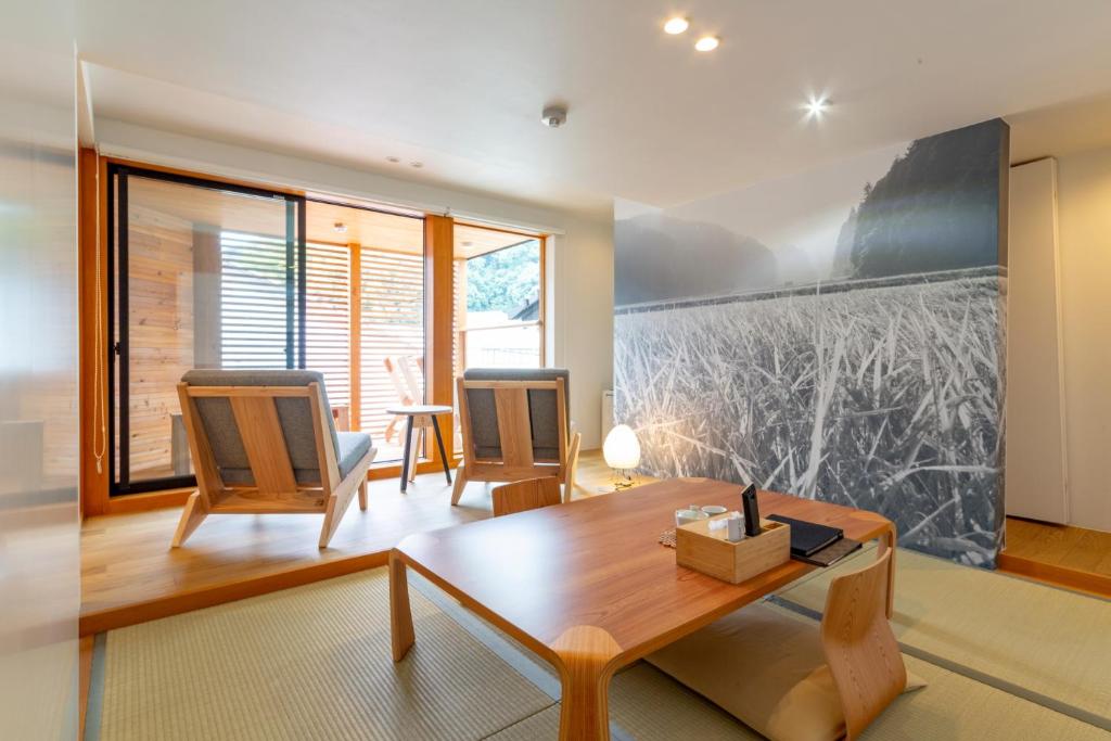 un salon avec une table et des chaises en bois dans l'établissement Kinosaki Onsen Kawaguchiya Honkan, à Toyooka
