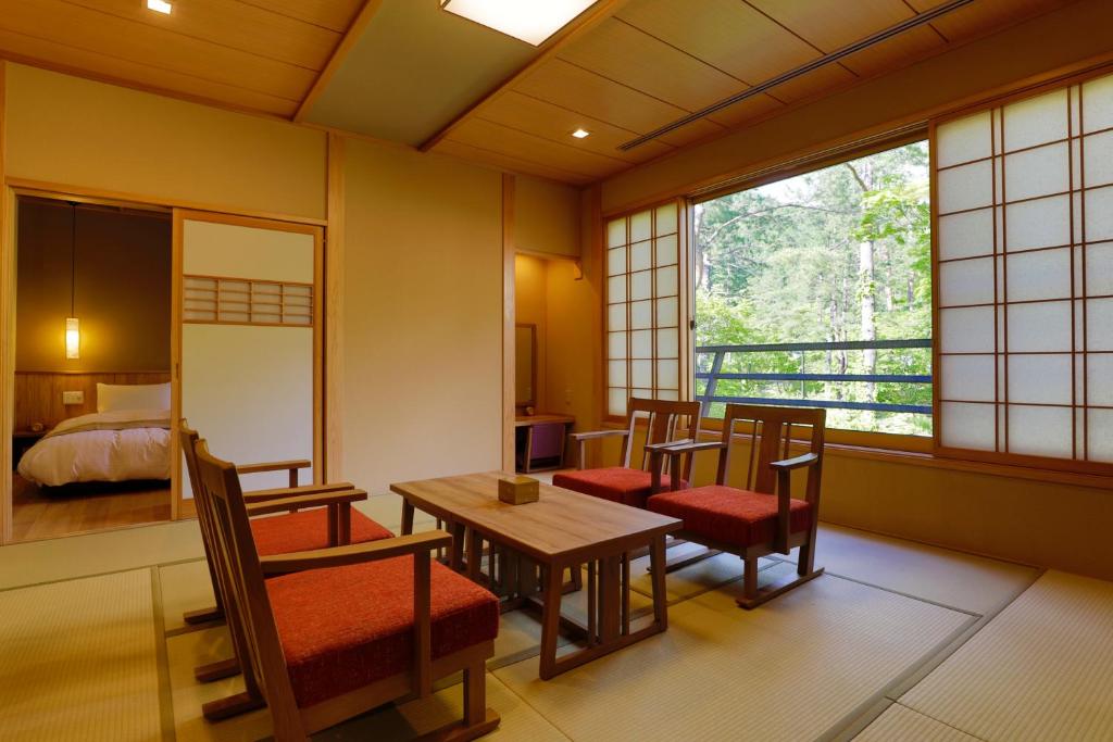 une pièce avec une table, des chaises et un lit dans l'établissement Yukemuri no Yado Inazumi Onsen, à Yuzawa 37 autres photos