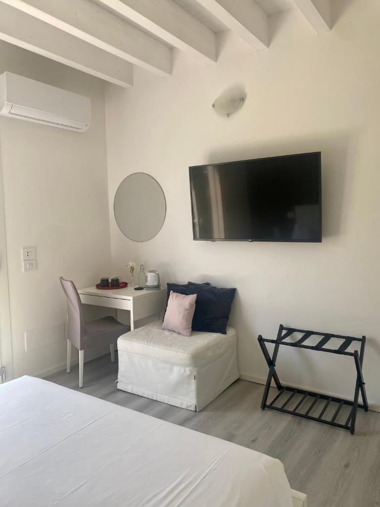 une chambre avec un lit, un bureau et une télévision dans l'établissement Villa Carlotta, à Salionze