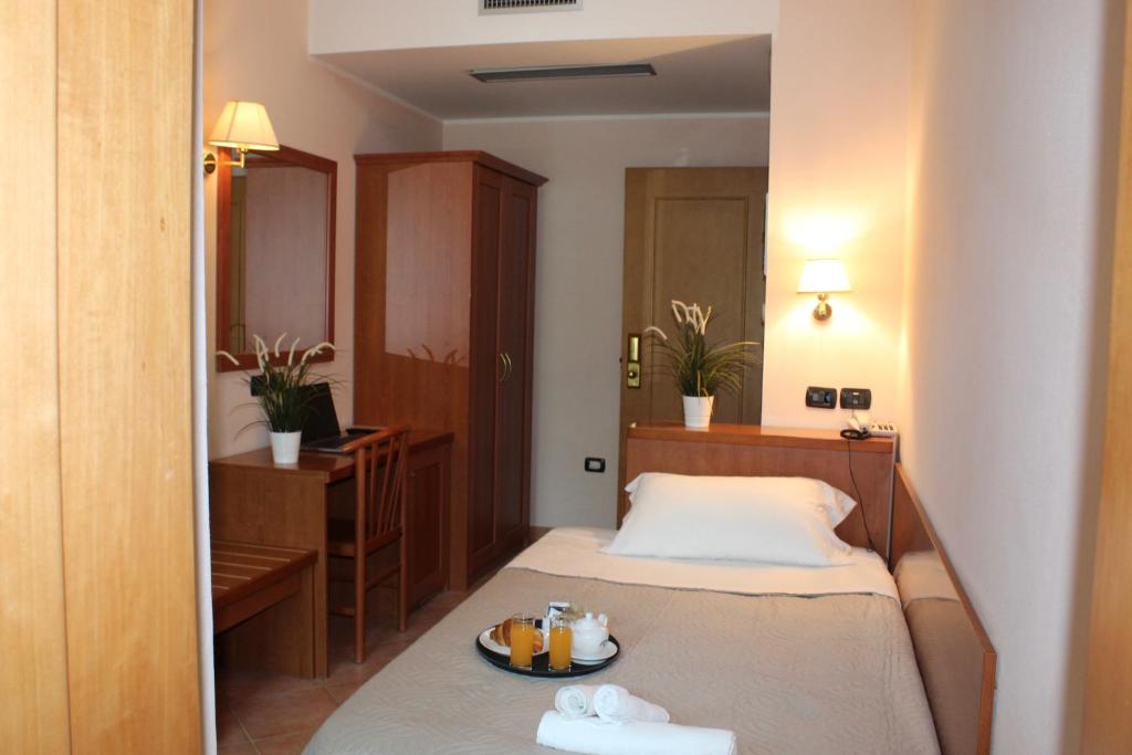 une chambre d'hôtel avec un lit et une assiette de nourriture dans l'établissement Jole Beach Hotel, à Cesenatico