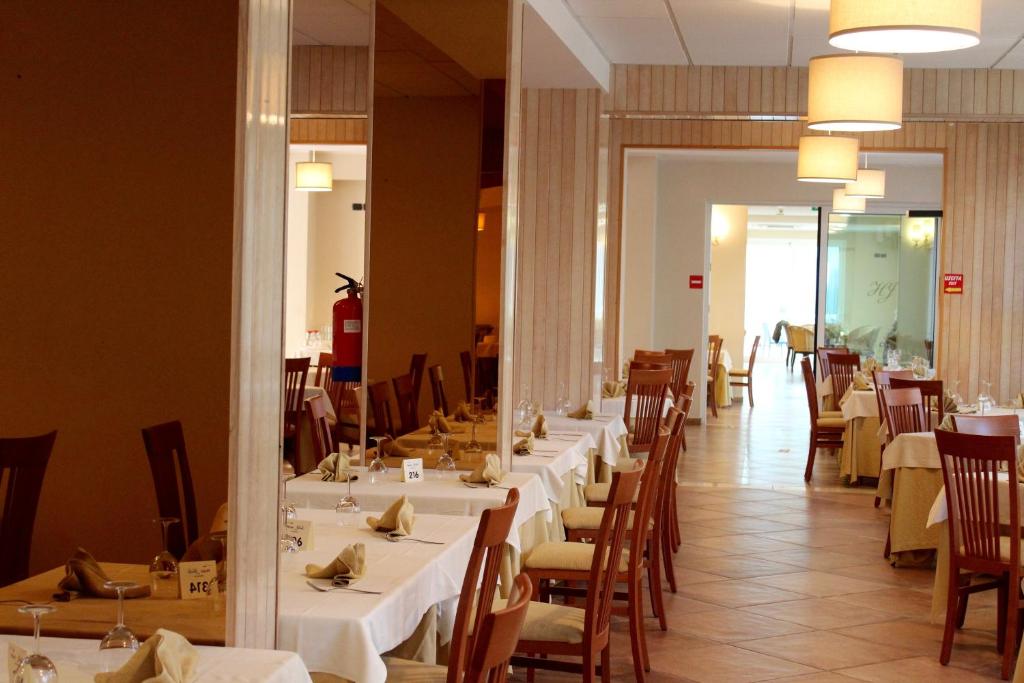 - une salle à manger avec des tables, des chaises et un miroir dans l'établissement Jole Beach Hotel, à Cesenatico