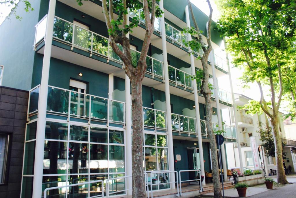 un immeuble d'appartements avec de grandes fenêtres et des plantes dans l'établissement Jole Beach Hotel, à Cesenatico