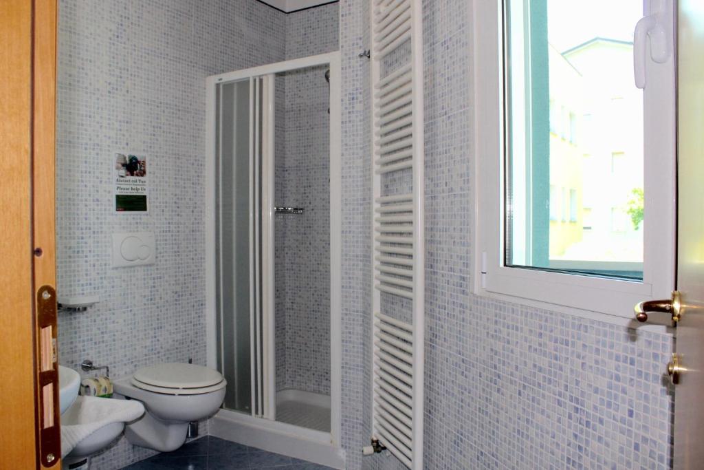 une salle de bain avec douche et toilettes et une fenêtre dans l'établissement Jole Beach Hotel, à Cesenatico