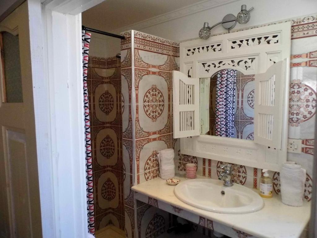 une salle de bain avec un lavabo et un miroir dans l'établissement Riad Marlinea, à Sale
