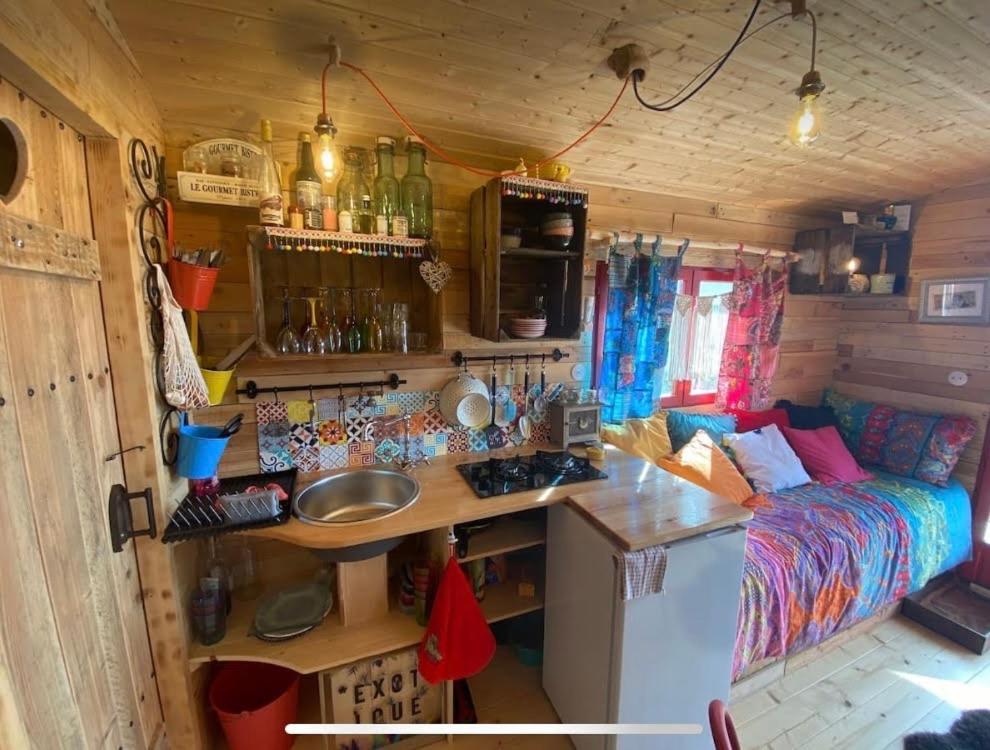 - une cuisine et un salon dans une petite maison dans l'établissement Roulotte de Charme, à Bréconchaux