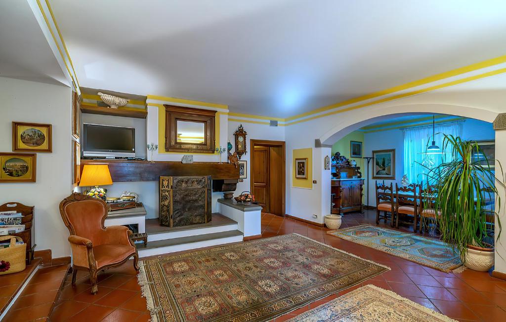 un salon avec une cheminée et une télévision dans l'établissement Tuscany Villa Gorello. Villa in Toscana. Jacuzzi con tetto in cristallo,piscina, à Arezzo