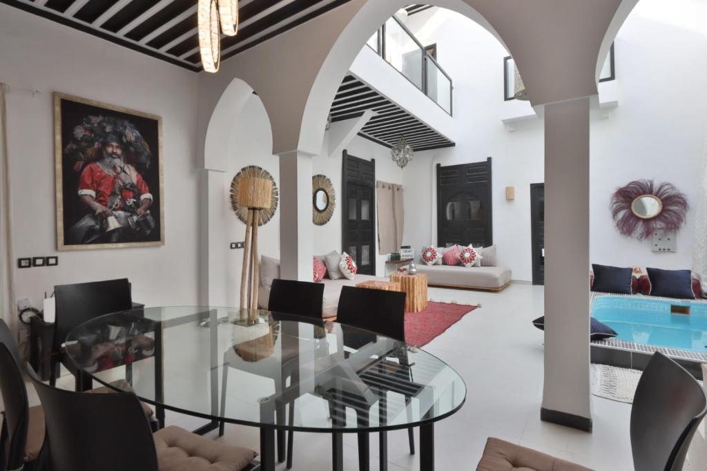 un salon avec une table en verre et des chaises dans l'établissement Riad Modern Bed & Breakfast, à Marrakech